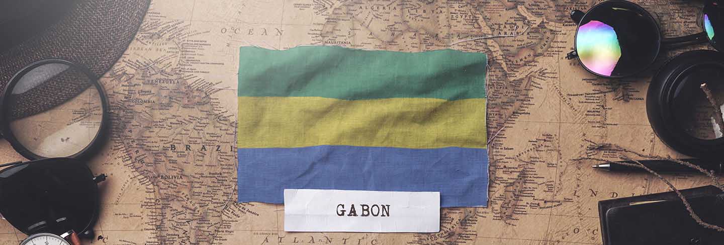 Gabon flag between traveler's accessories on old vintage map