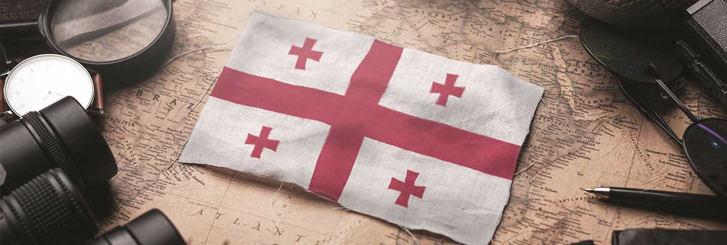 Georgia flag between traveler's accessories on old vintage map