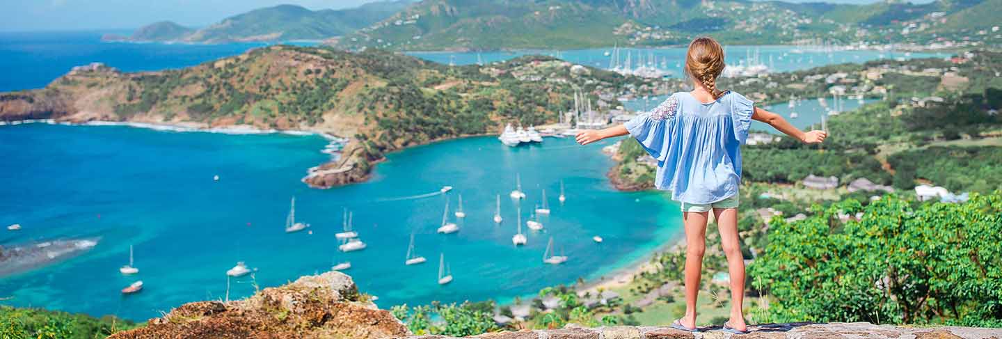 Adorable little kid enjoying the view of picturesque english harbour at antigua in caribbean