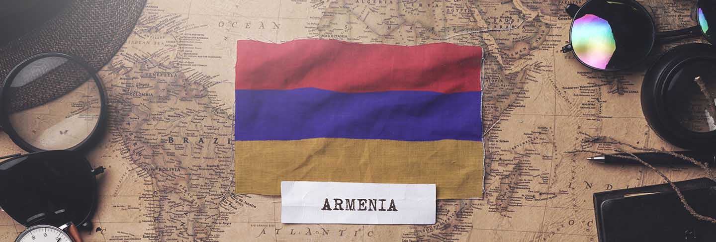 Armenia flag between traveler's accessories on old vintage map