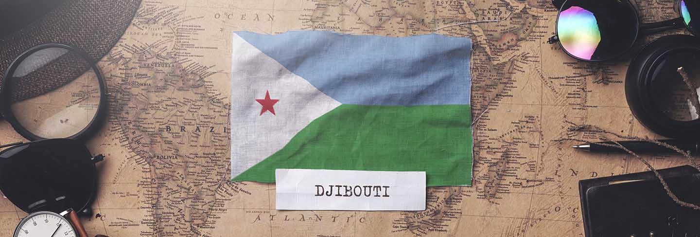 Djibouti flag between traveler's accessories on old vintage map