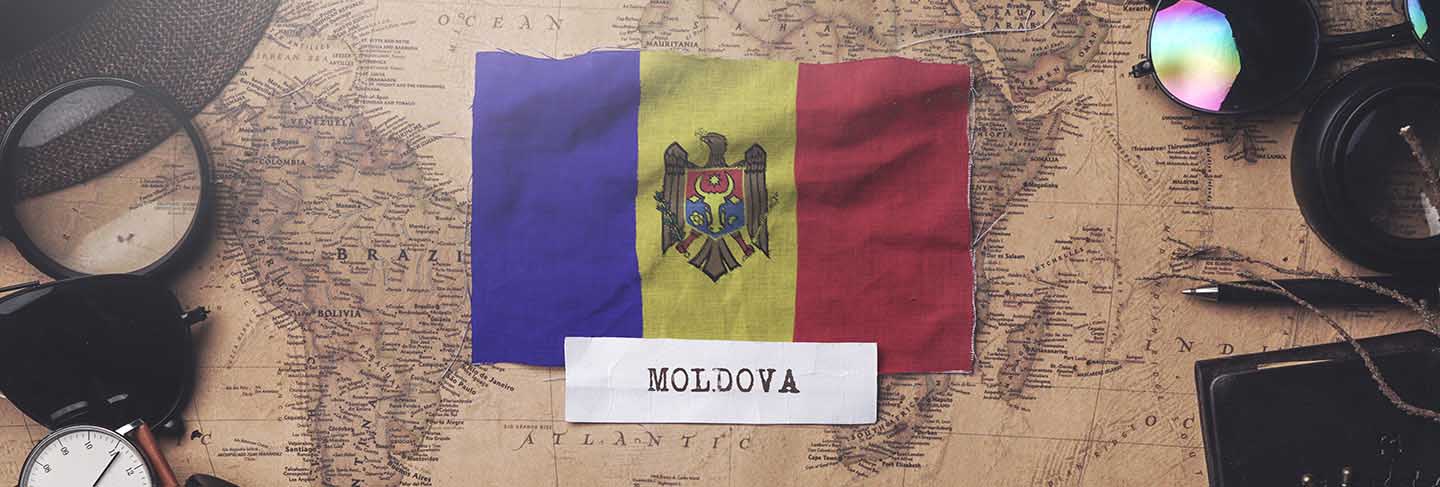 Moldova flag between traveler's accessories on old vintage map