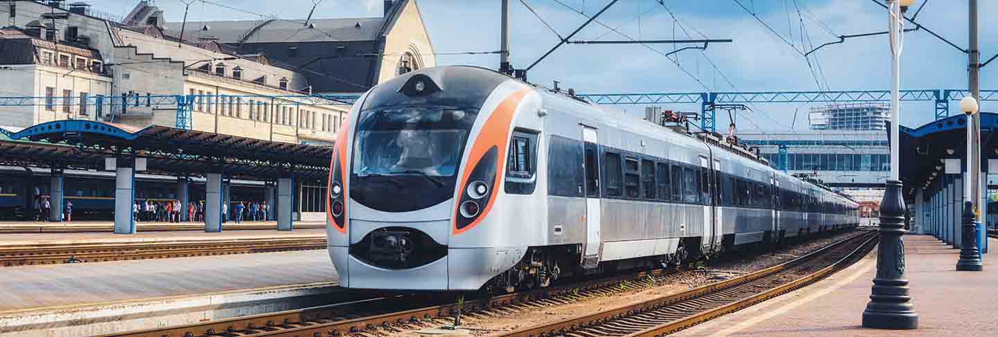 High speed train at the railway station in ukraine. modern intercity train on the railway platform. urban scene with railroad, buildings and blue cloudy sky