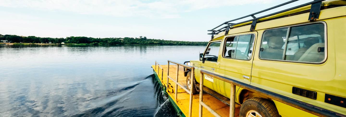 Wide shot of a yellow van on a yellow dock by the sea under a clear sky with clouds