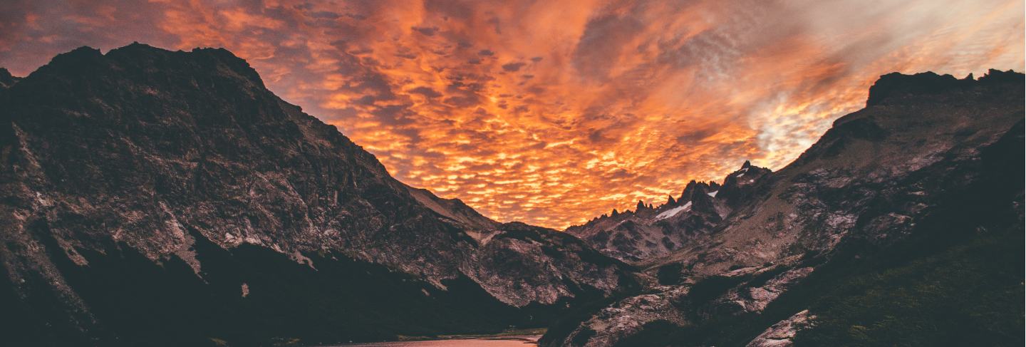 Beautiful shot of the sunset in the mountains by the lake with amazing clouds 