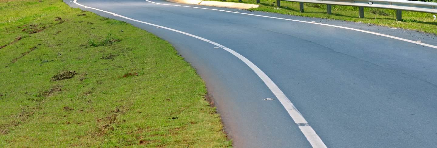 Winding highway with green fields on the horizon