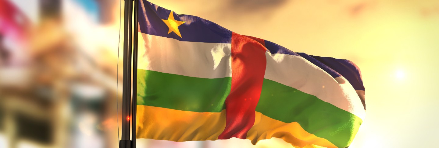 Central african republic flag against city blurred background at sunrise backlight