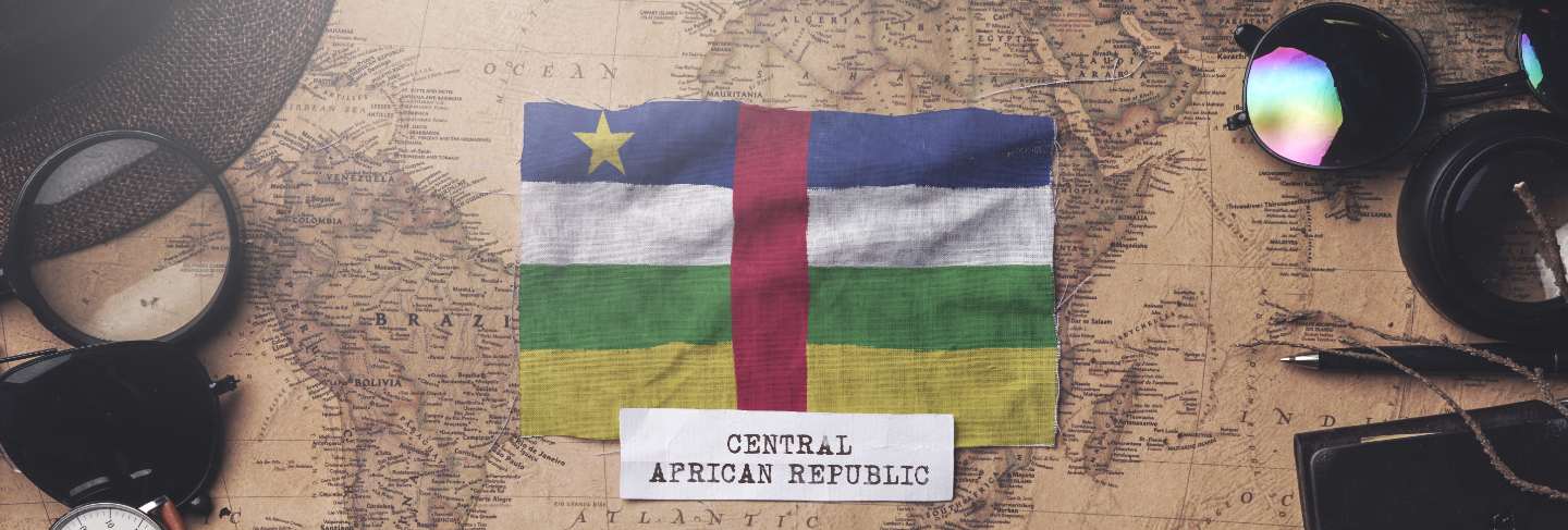 Central african republic flag between traveler's accessories on old vintage map. overhead shot