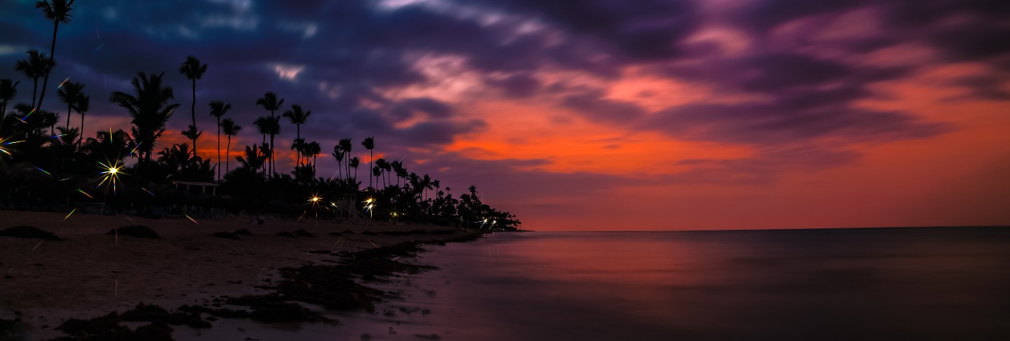 Dramatic sunset over the exotic beach, with palms
