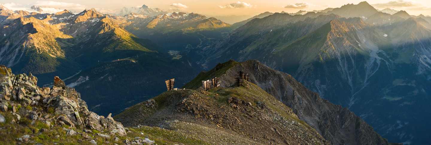 Warm light at sunrise on mountain peaks, ridges and valleys 
