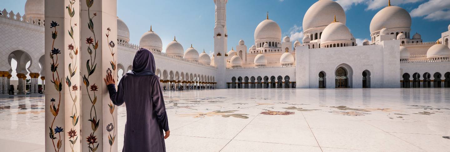 Woman with traditional dress inside sheikh zayed mosque. abu dhabi, united arab emirates.