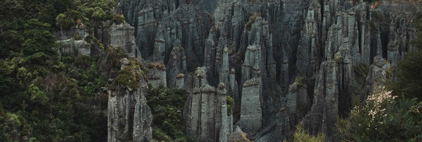 Beautiful aerial shot of rocks formation between forest on a hill
