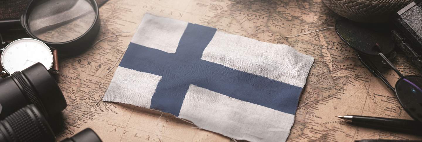 Finland flag between traveler's accessories on old vintage map. tourist destination concept
