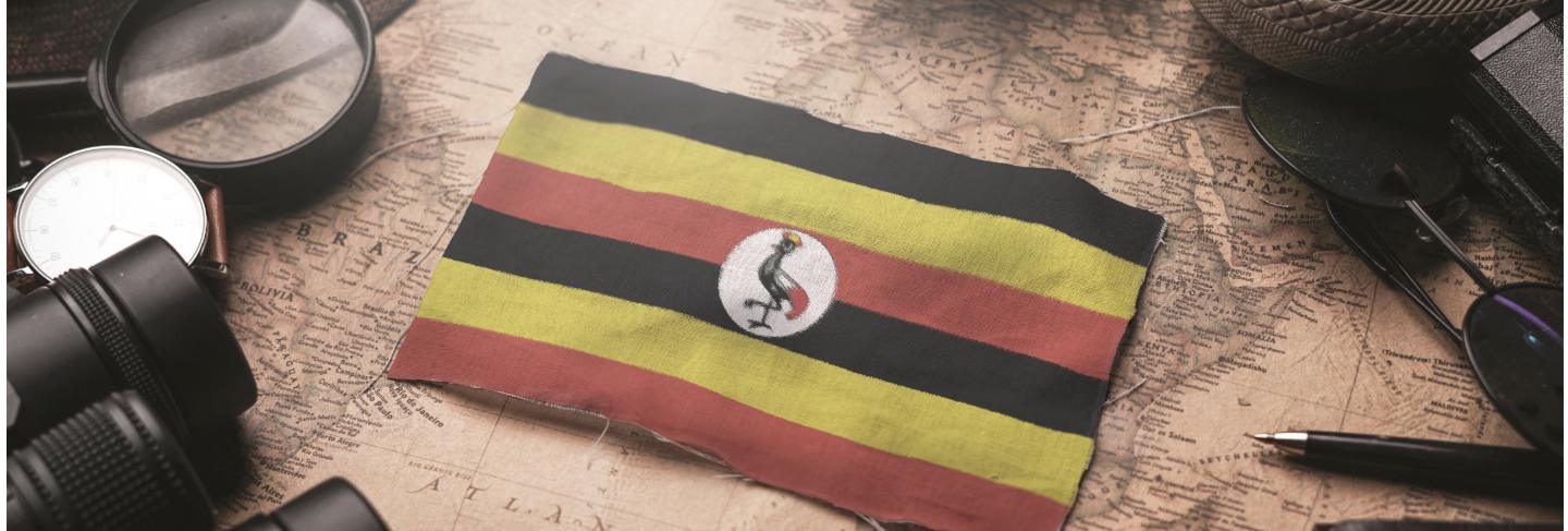 Uganda flag between traveler's accessories on old vintage map. tourist destination concept.
