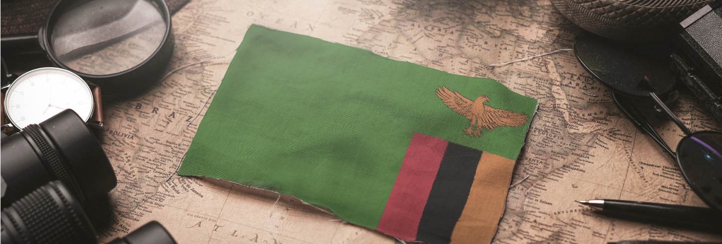 Zambia flag between traveler's accessories on old vintage map. tourist destination concept