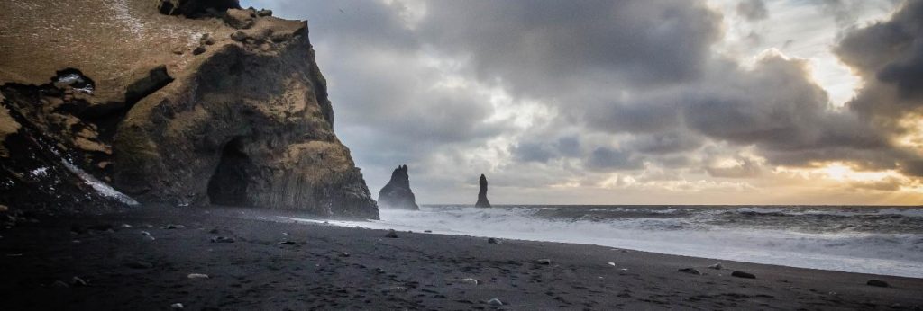 Beautiful coast of the sea at vik, iceland with breathtaking clouds and rocks on the side 
