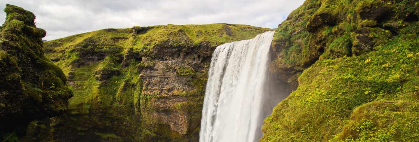 Waterfall between green mountains