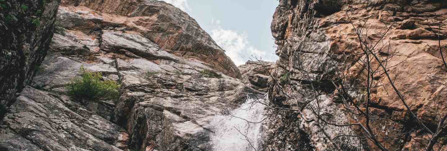 Small waterfall in the rocky mountains shot from below
