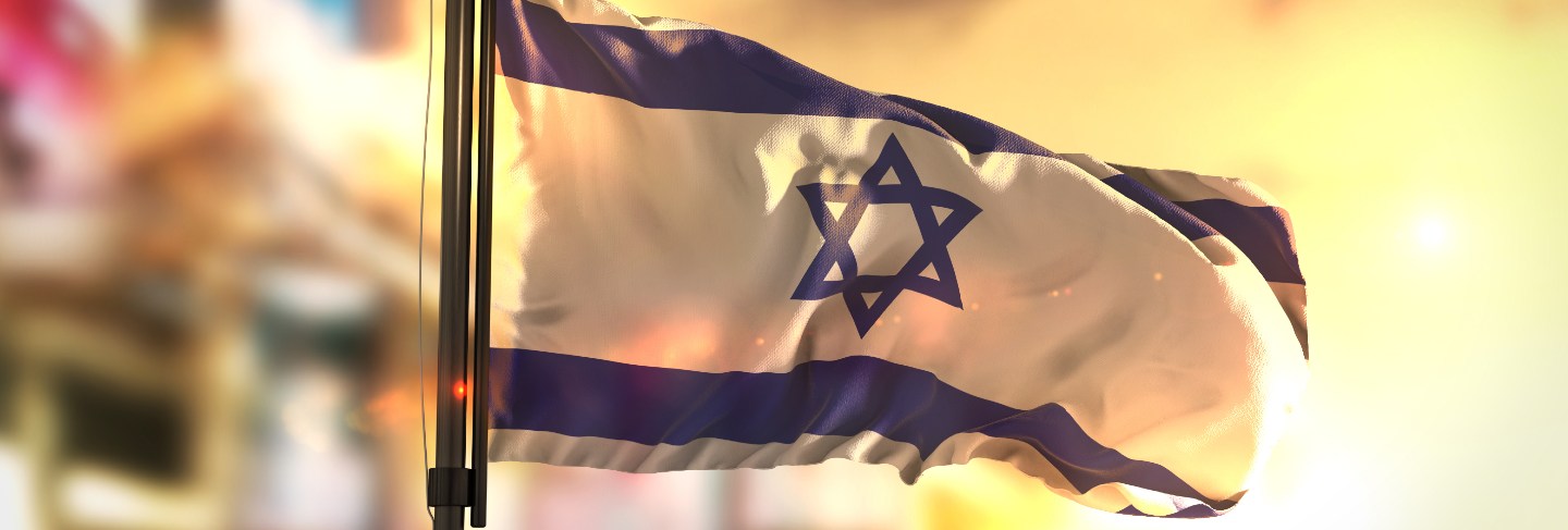 Israel flag against city blurred background at sunrise backlight 
