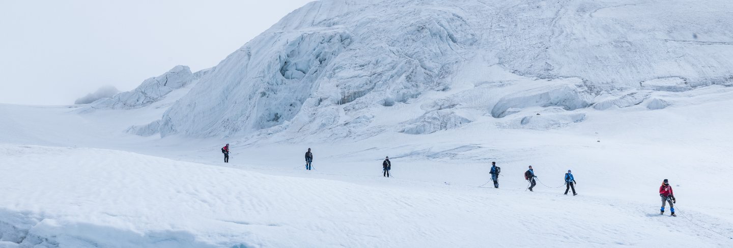 Expedition of hikers in the snowy steep mountains
