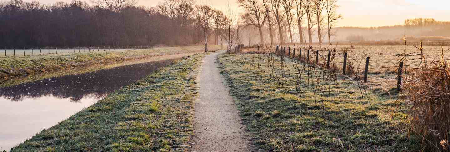 Fantastic calm river with fresh grass in the sunset. beautiful green winter landscape on a cold day in the morning in the netherlands