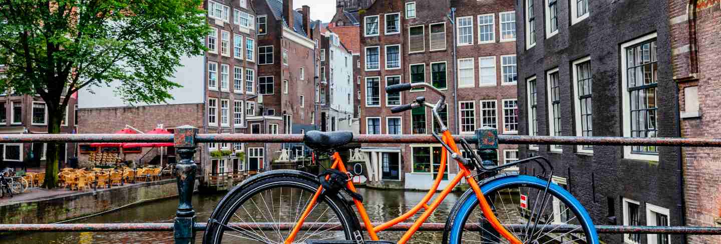 Beautiful view of the canal in amsterdam. houses on the water, bicycles with flowers nm bridge. great cityscape.
