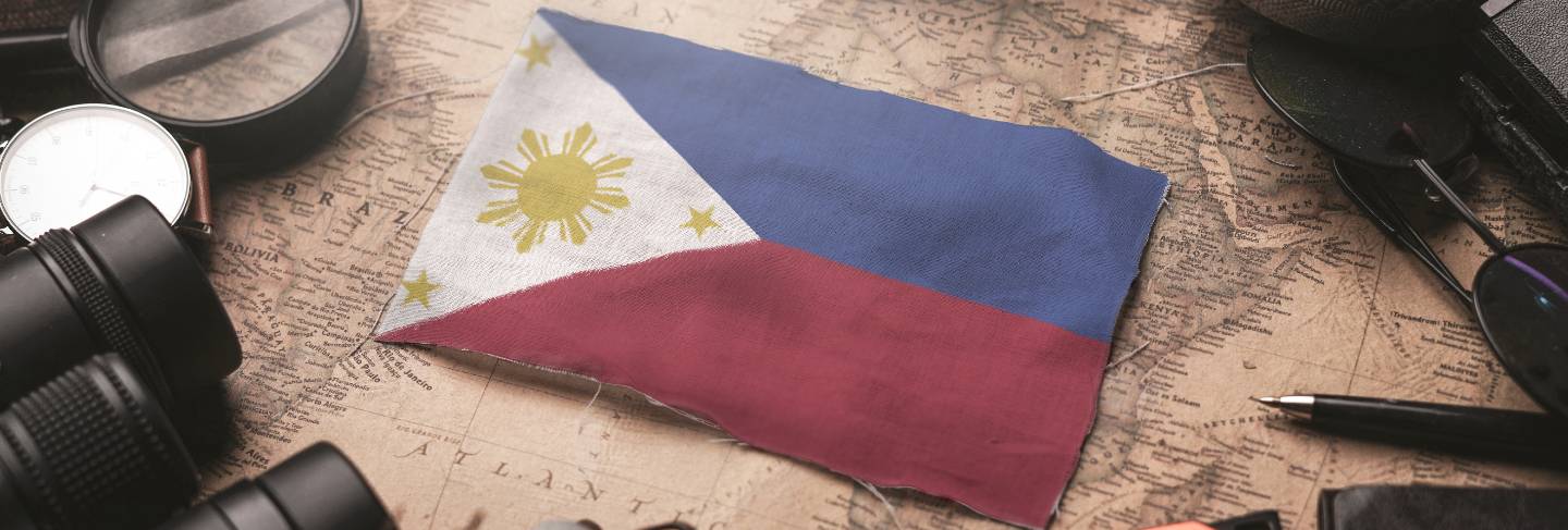 Philippines flag between traveler's accessories on old vintage map. tourist destination concept
