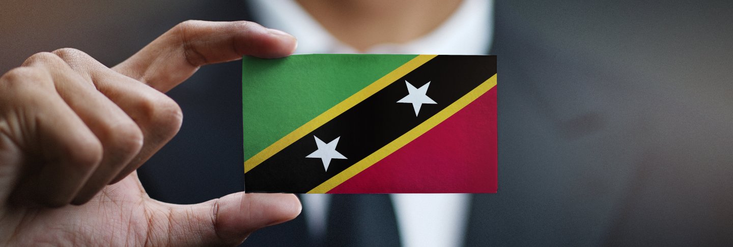 Businessman holding card of saint kitts and nevis flag
