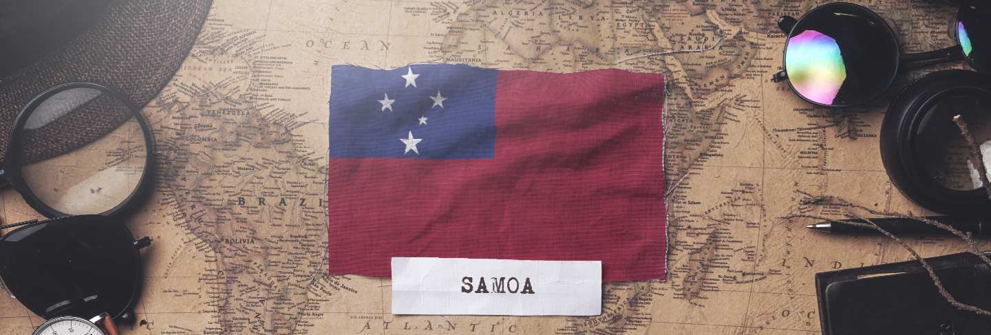 Samoa flag between traveler's accessories on old vintage map.
