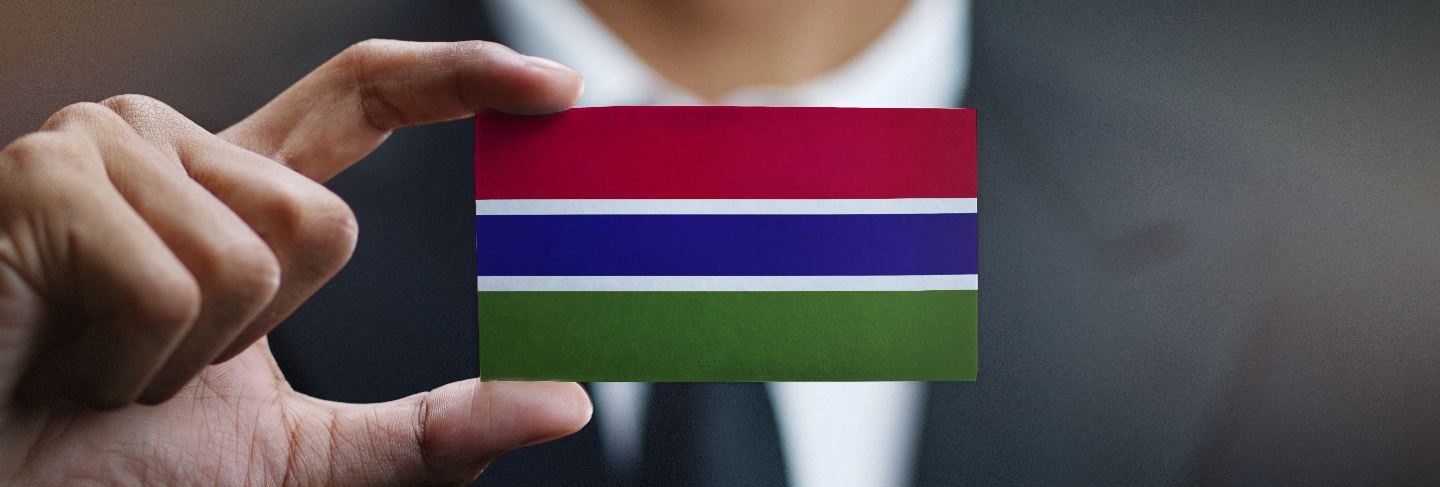 Businessman holding card of the gambia flag
