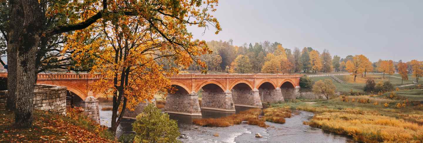 Autumn landscape. the old brick bridge across the venta river in kuldiga, latvia
