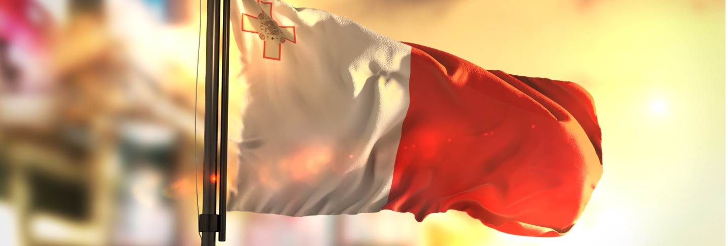 Malta flag against city blurred background at sunrise backlight Premium Photo
