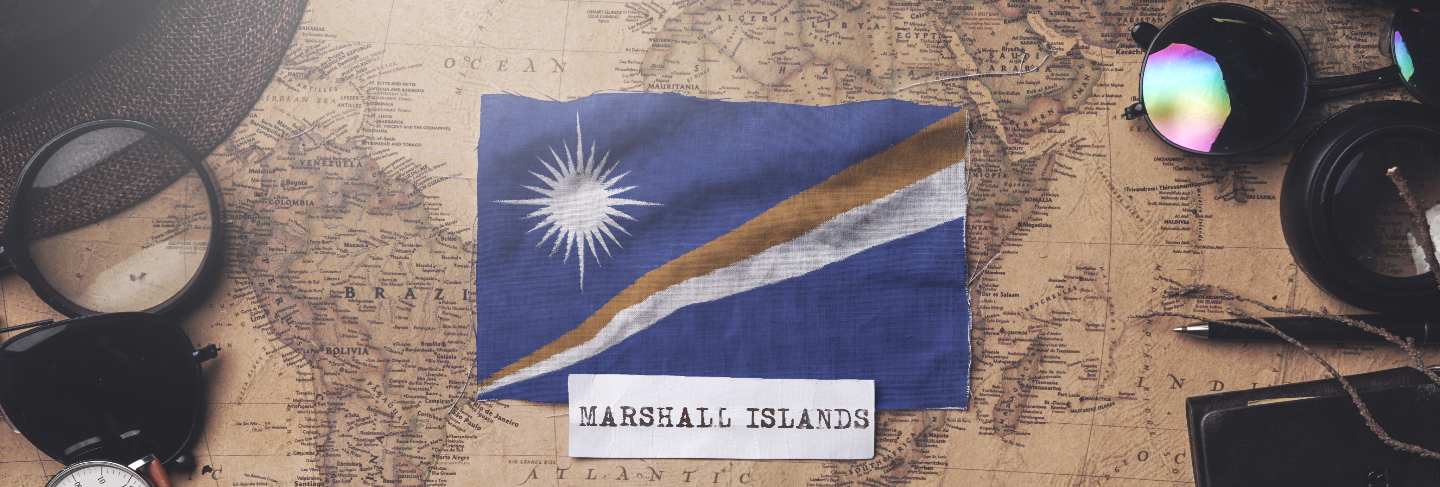 Marshall islands flag between traveler's accessories on old vintage map. overhead shot Premium Photo