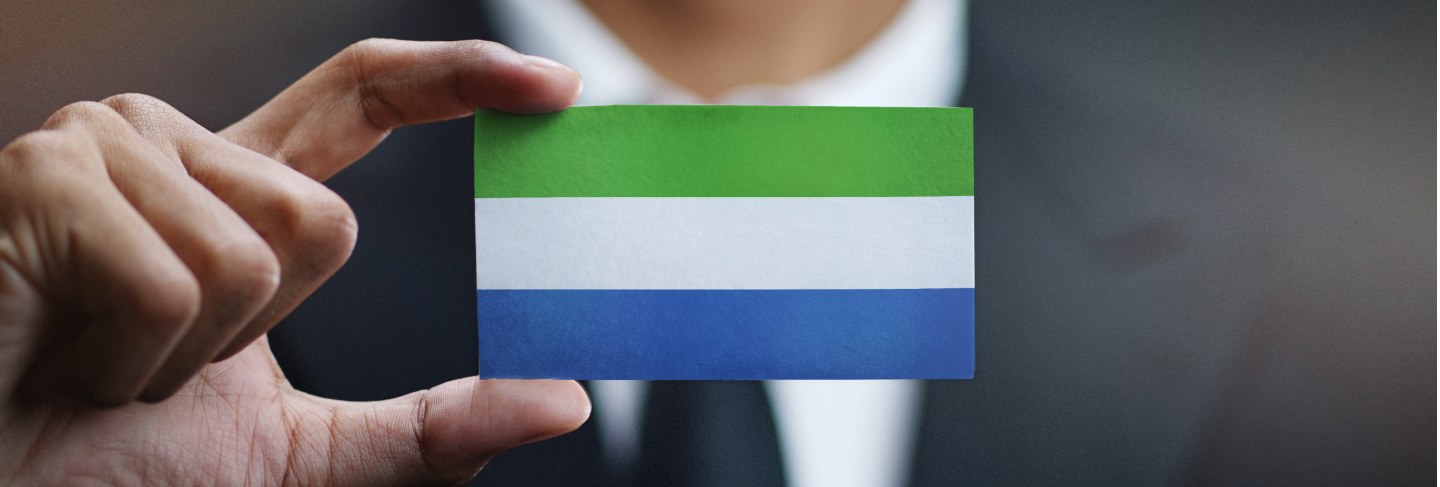 Businessman holding card of sierra leone flag
