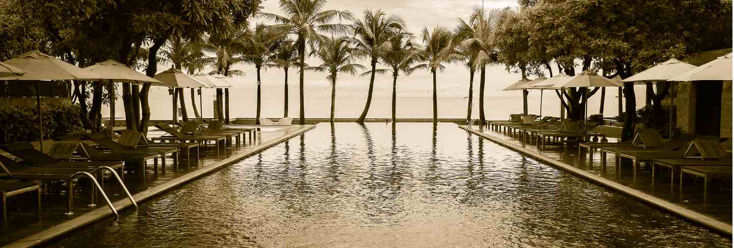 Silhouette palm tree on the beach with swimming pool
