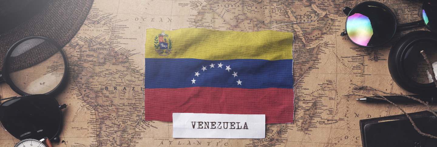 Venezuela flag between traveler's accessories on old vintage map. overhead shot 