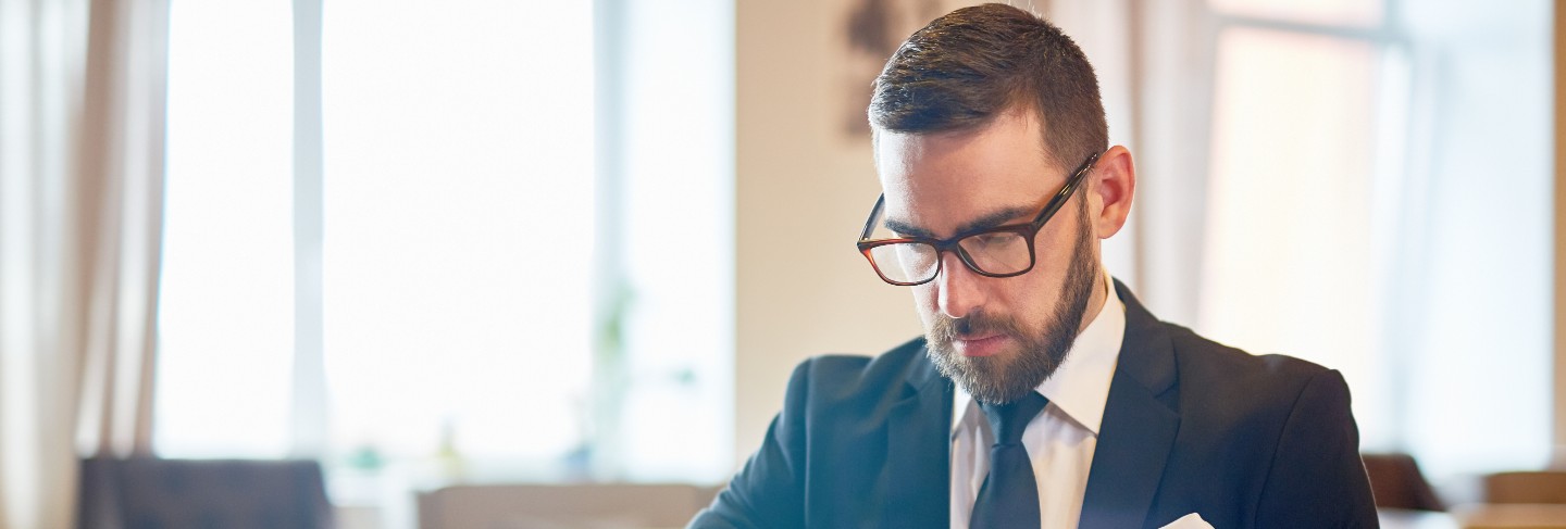 Cheerful businessman in eyeglasses in office
