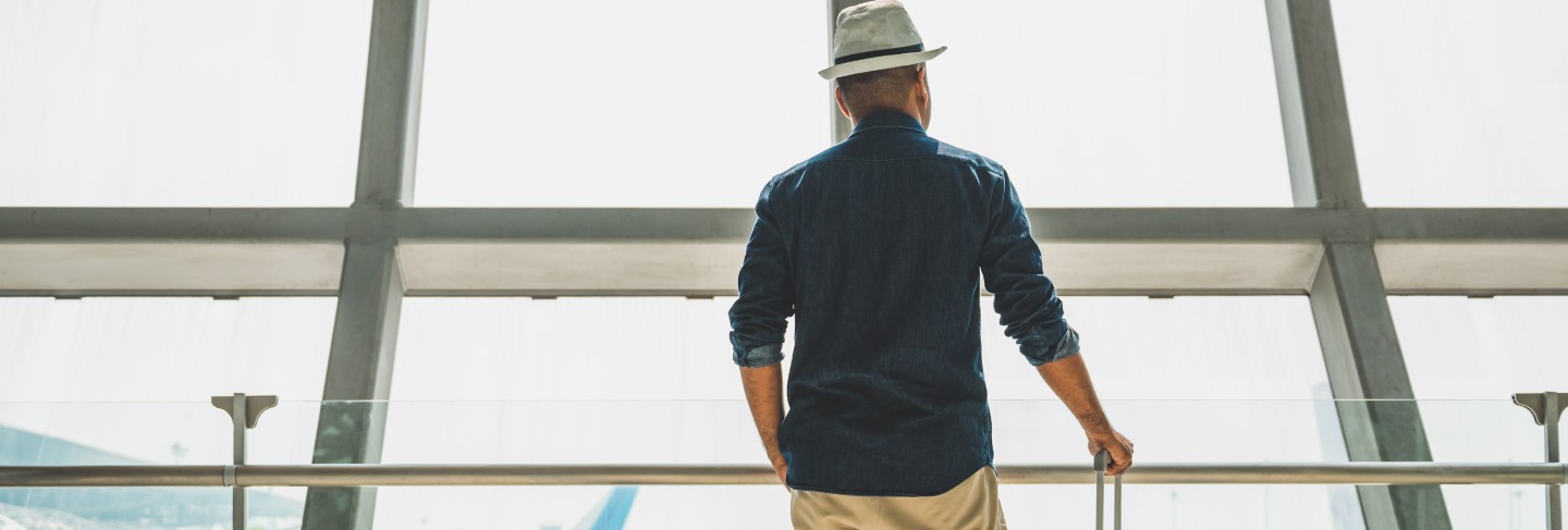 Male traveler wearing a gray hat preparing to travel
