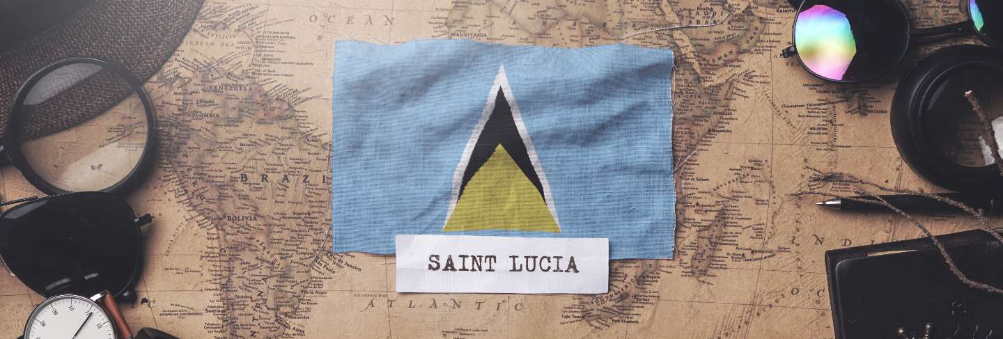 Saint lucia flag between traveler's accessories on old vintage map. 
