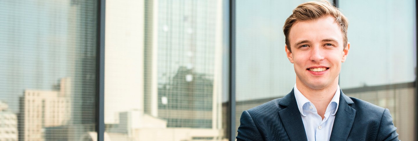 Smiling businessman with crossed arms looking at camera
