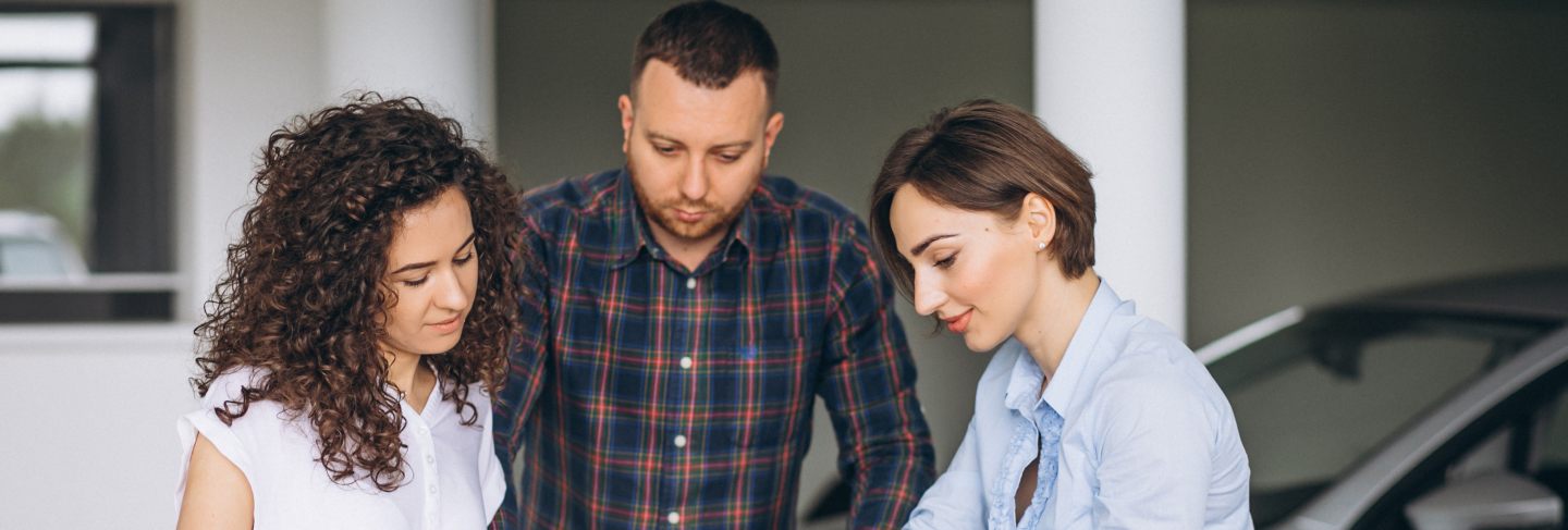 Young couple byuing a car in a car showroom
