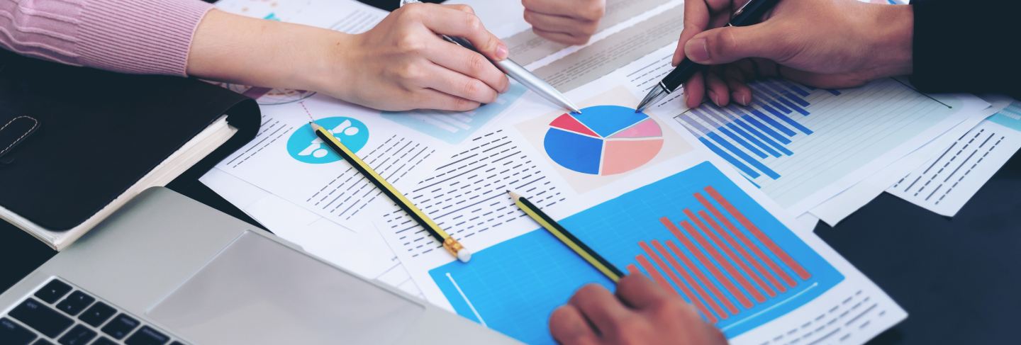 Close up hand of business man busy at office desk on notebook and documents working

