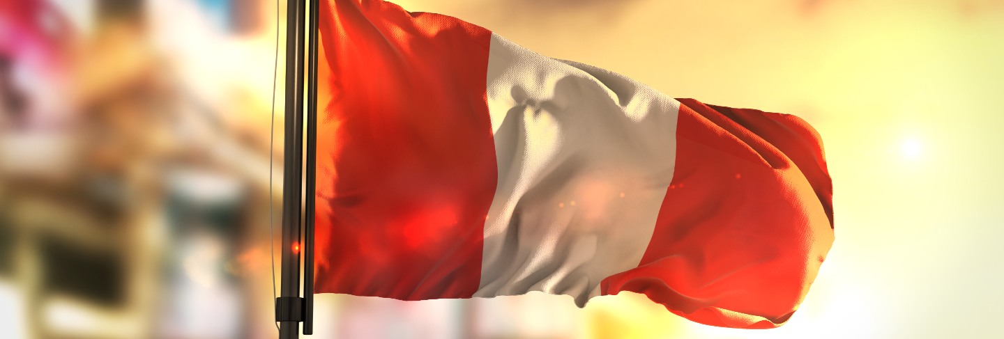 Peru flag against city blurred background at sunrise backlight
