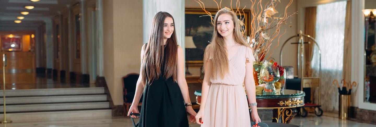 Young girls near reception desk in hotel, young girls comes to the hotel.
