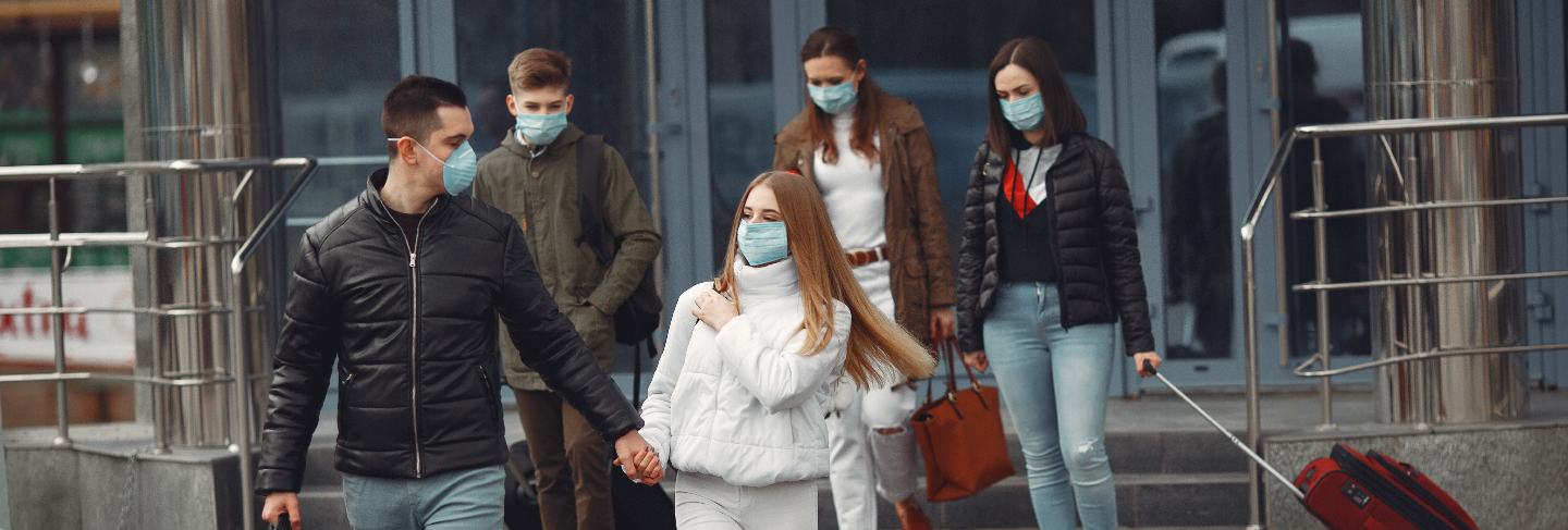 Travelers leaving airport are wearing protective masks
